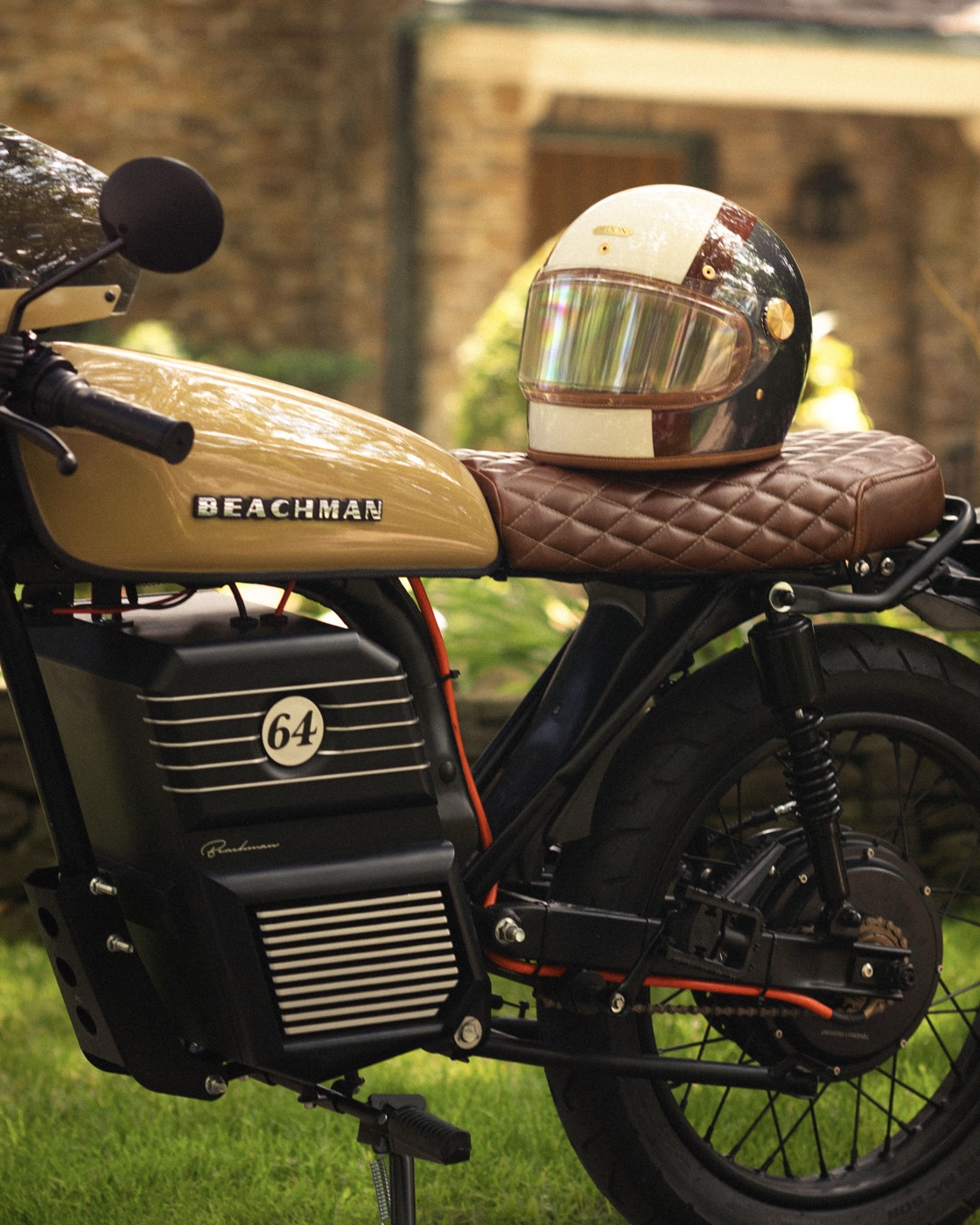 Detail of a Beachman bike with a vintage helmet by a stone house