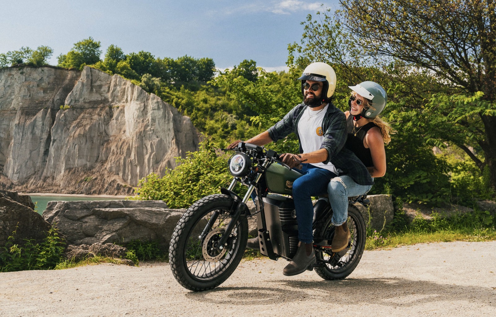 Couple riding a Beachman bike past a quarry on a summer day