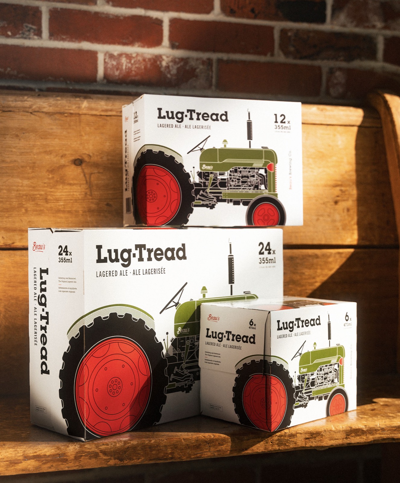 Beau's Lug Tread beer cases stacked on wood against a brick wall