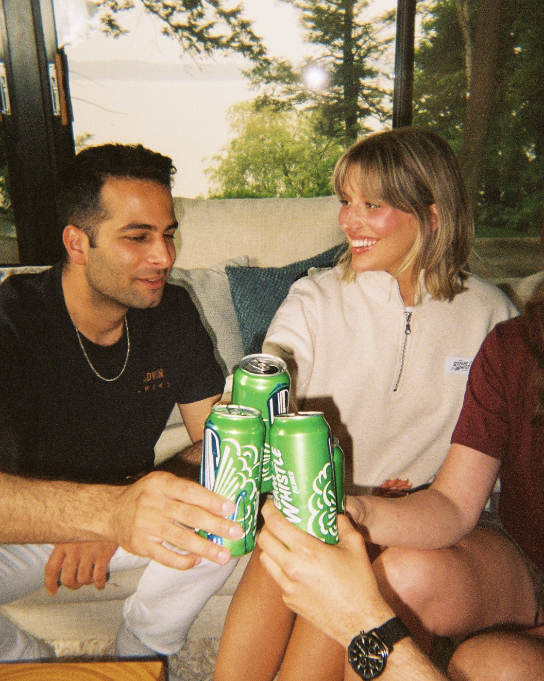 Friends clinking cans, shot on a disposable film camera