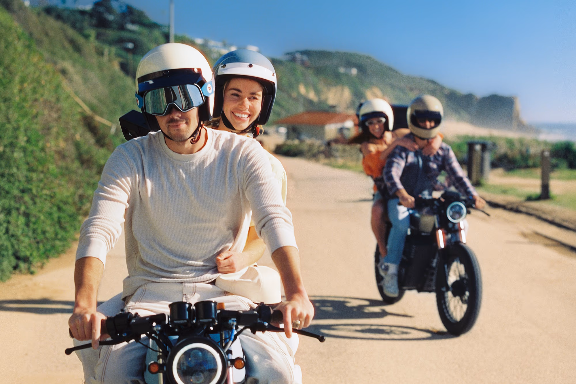 Riding down the hill road toward the sea, a second bike trailing
