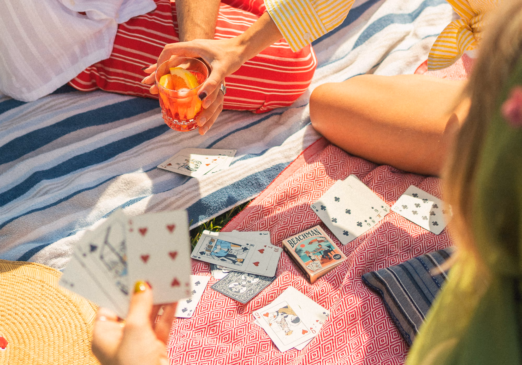 The picnic from above — cards, sun hat and drinks on the lawn