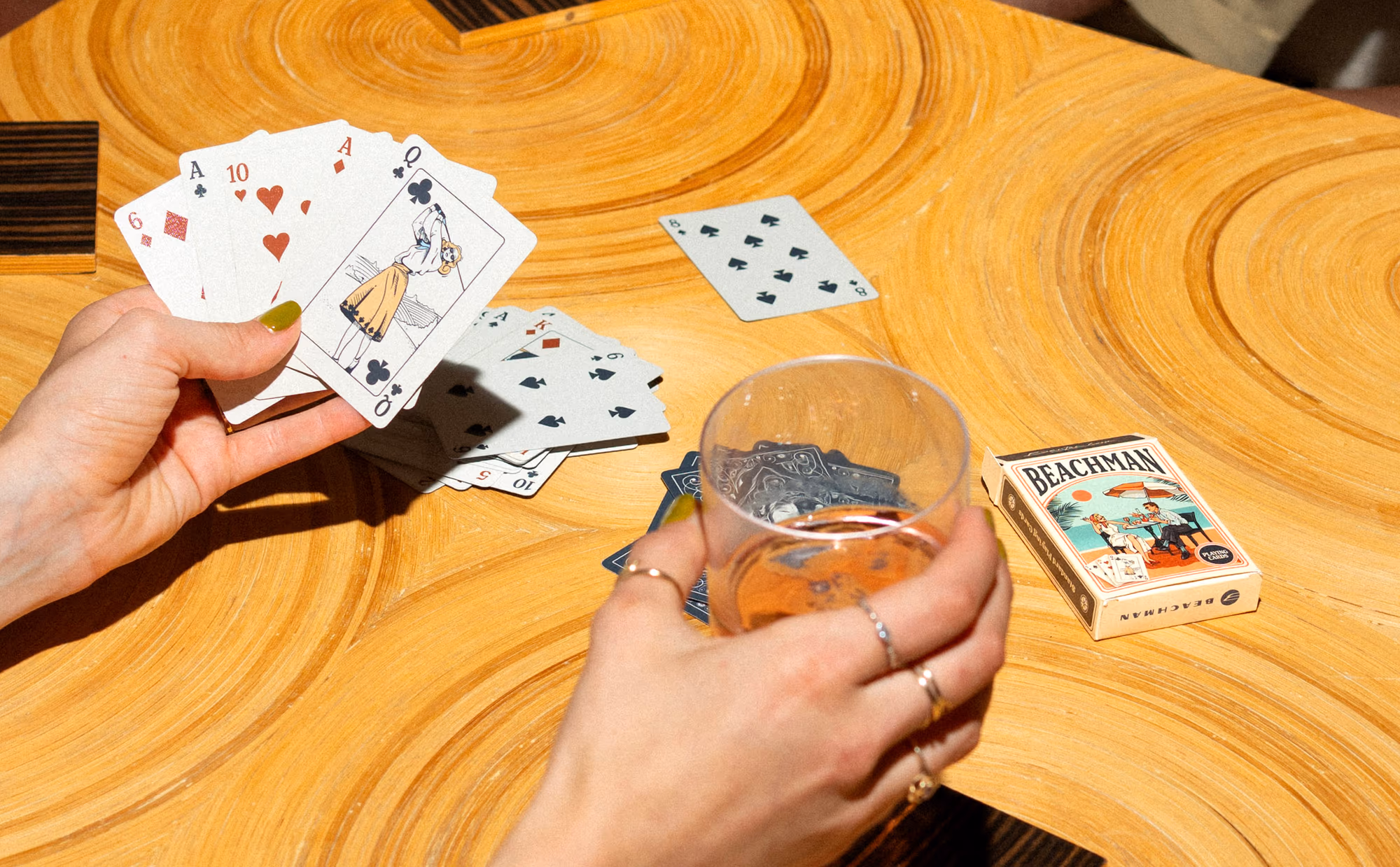 Cards, a glass and the Beachman playing-card box on the tabletop