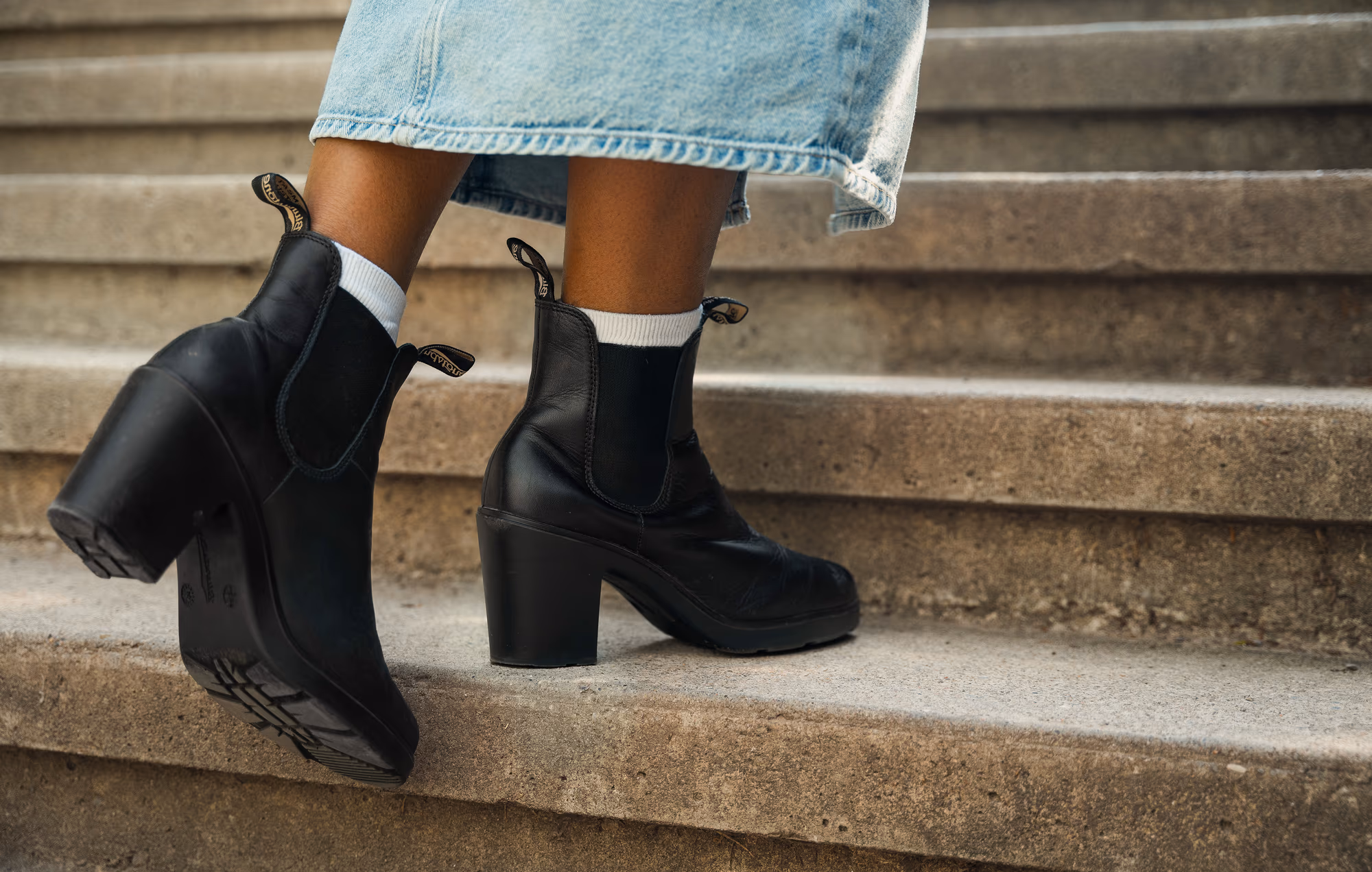 The heeled black Chelsea boots up close on the concrete steps
