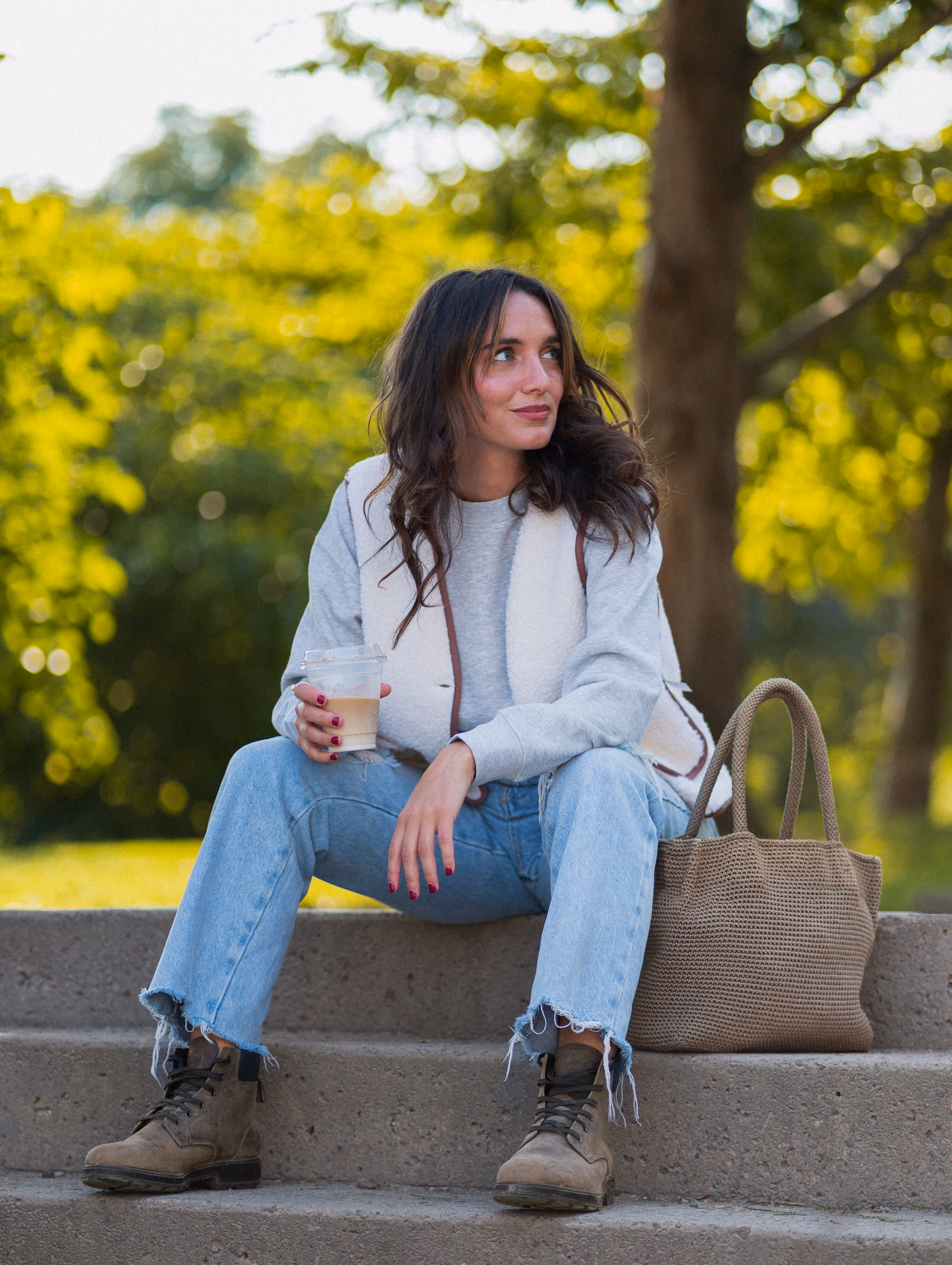 Iced coffee on the park steps, woven tote and lace-up boots