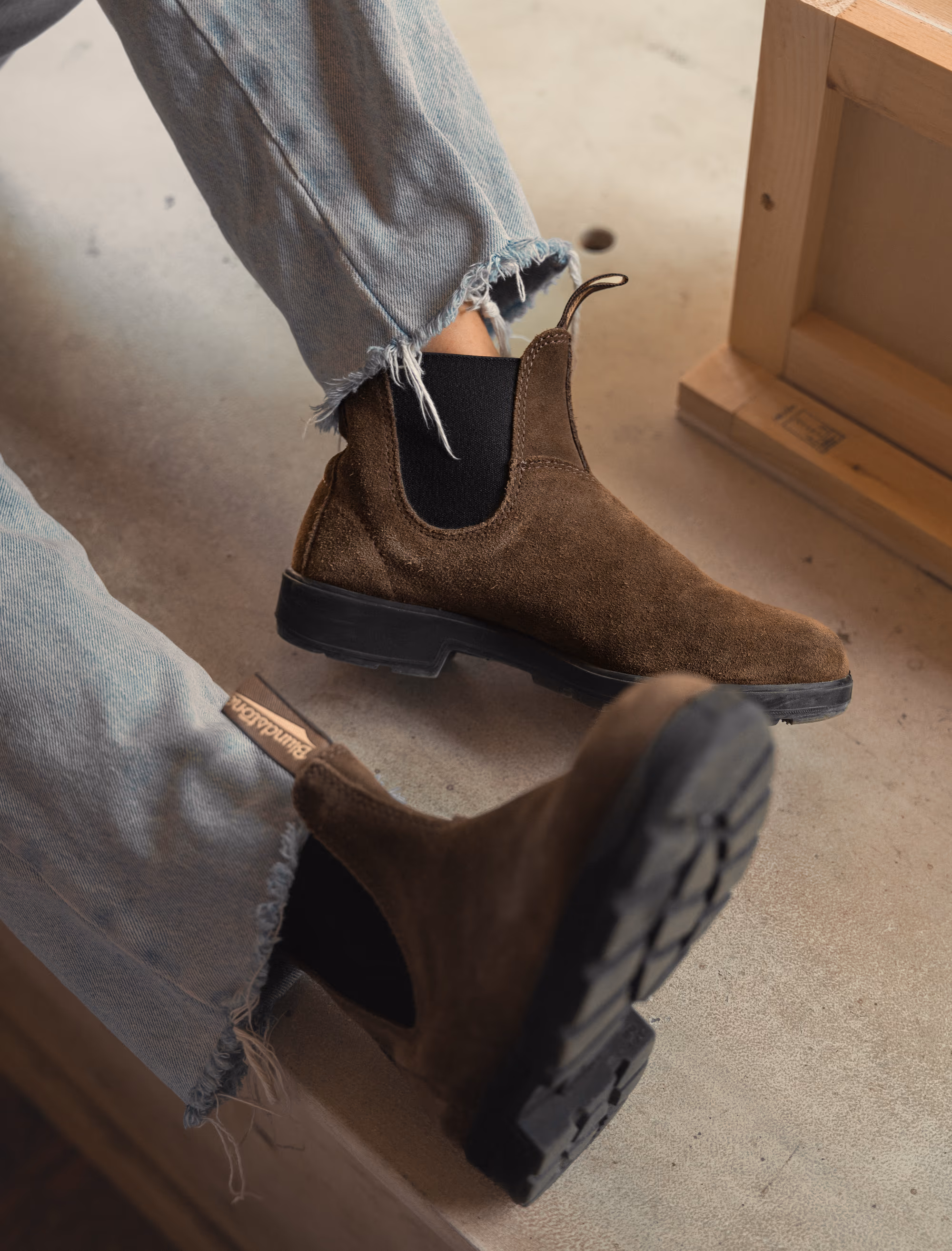 Overhead detail of the dark olive suede boots and frayed denim hem