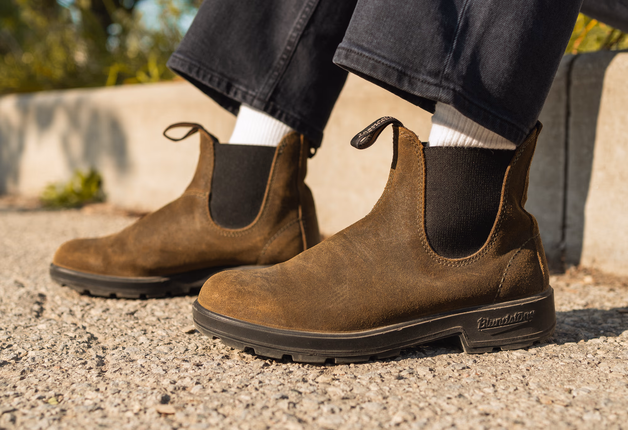 The olive Chelsea boots at the curb, white socks and black denim