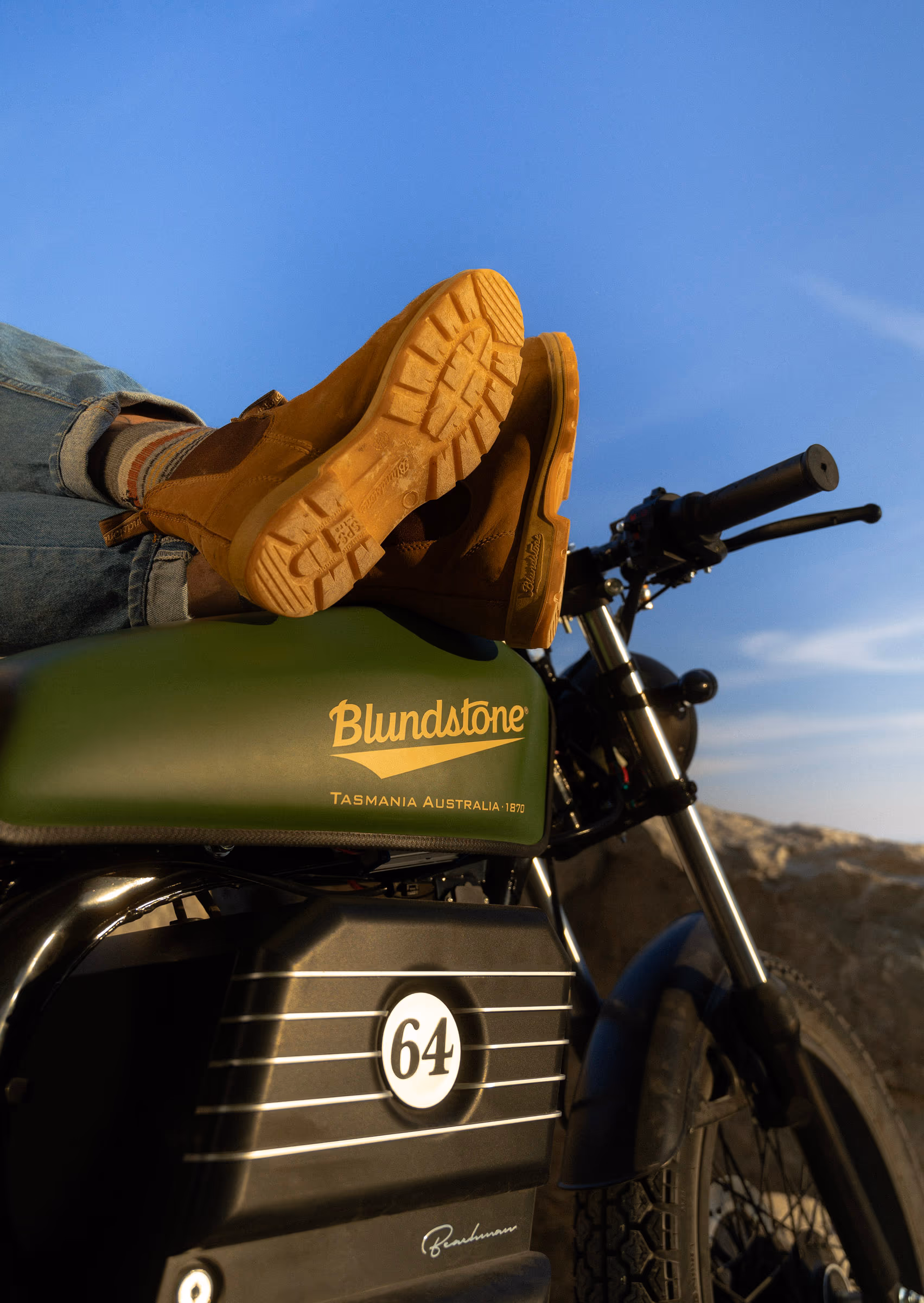 Boots kicked up on the handlebars, Blundstone patch on the seat
