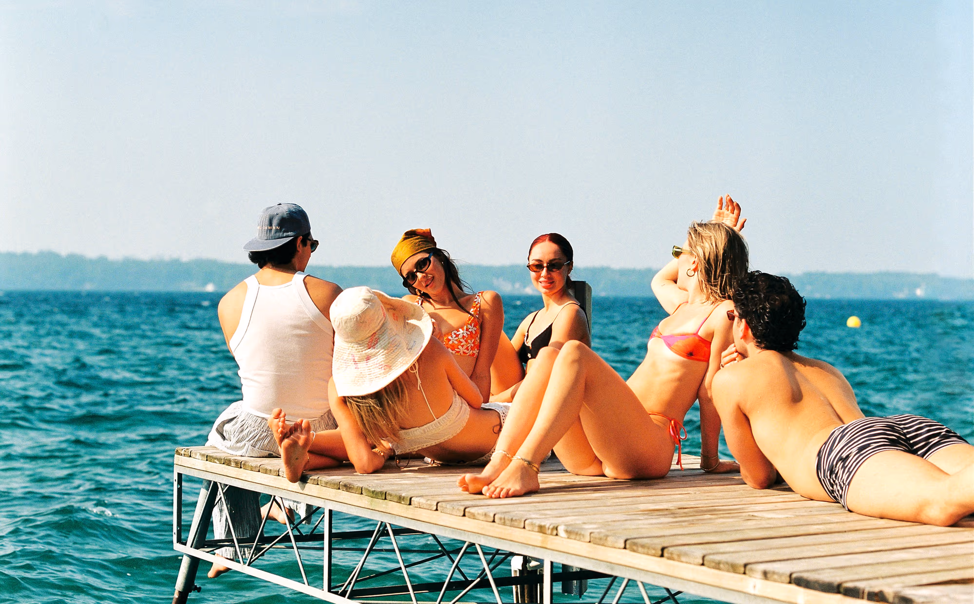 A couple laughing over spritzes on the dock blanket