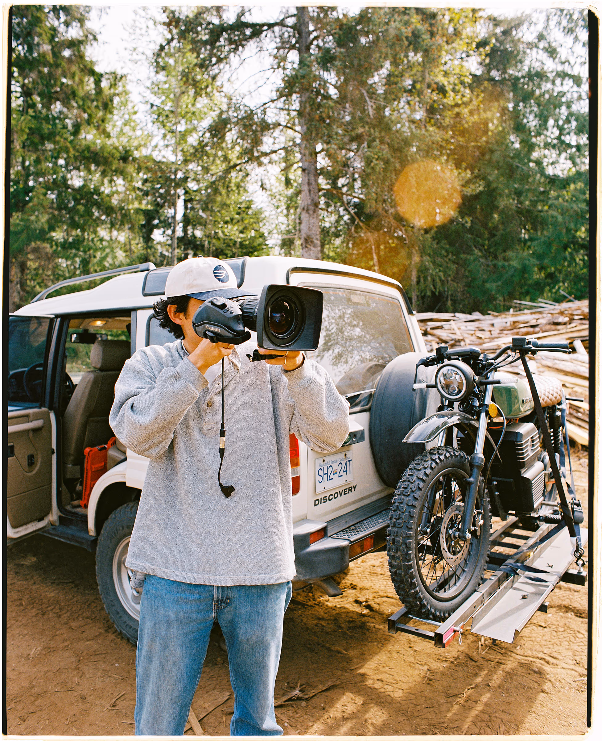 Eric Shiozaki filming beside a 4x4 with a motorbike loaded on the back