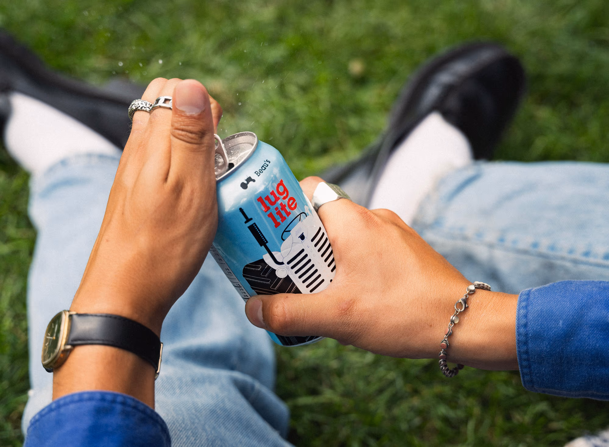 Two cans knocked together over a blue shirt sleeve