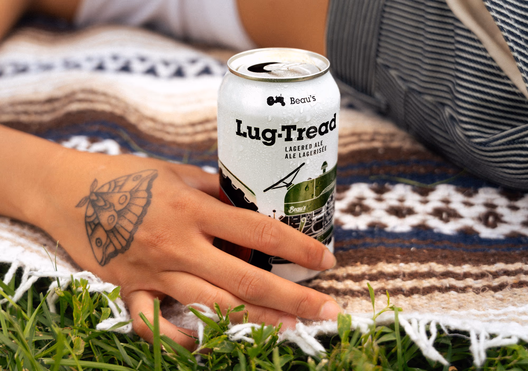 A can resting on the picnic blanket