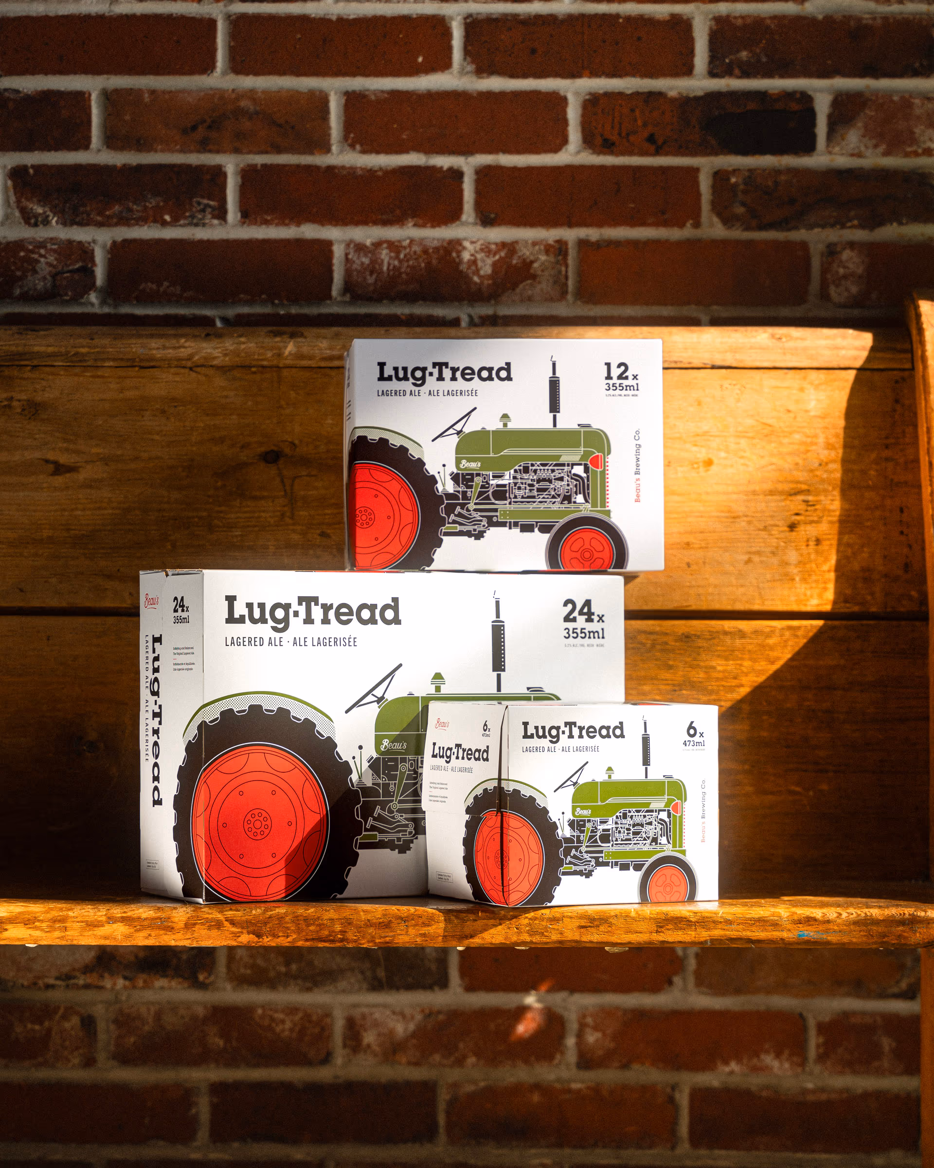 Beau's Lug Tread 12- and 24-packs stacked on a wooden shelf against brick