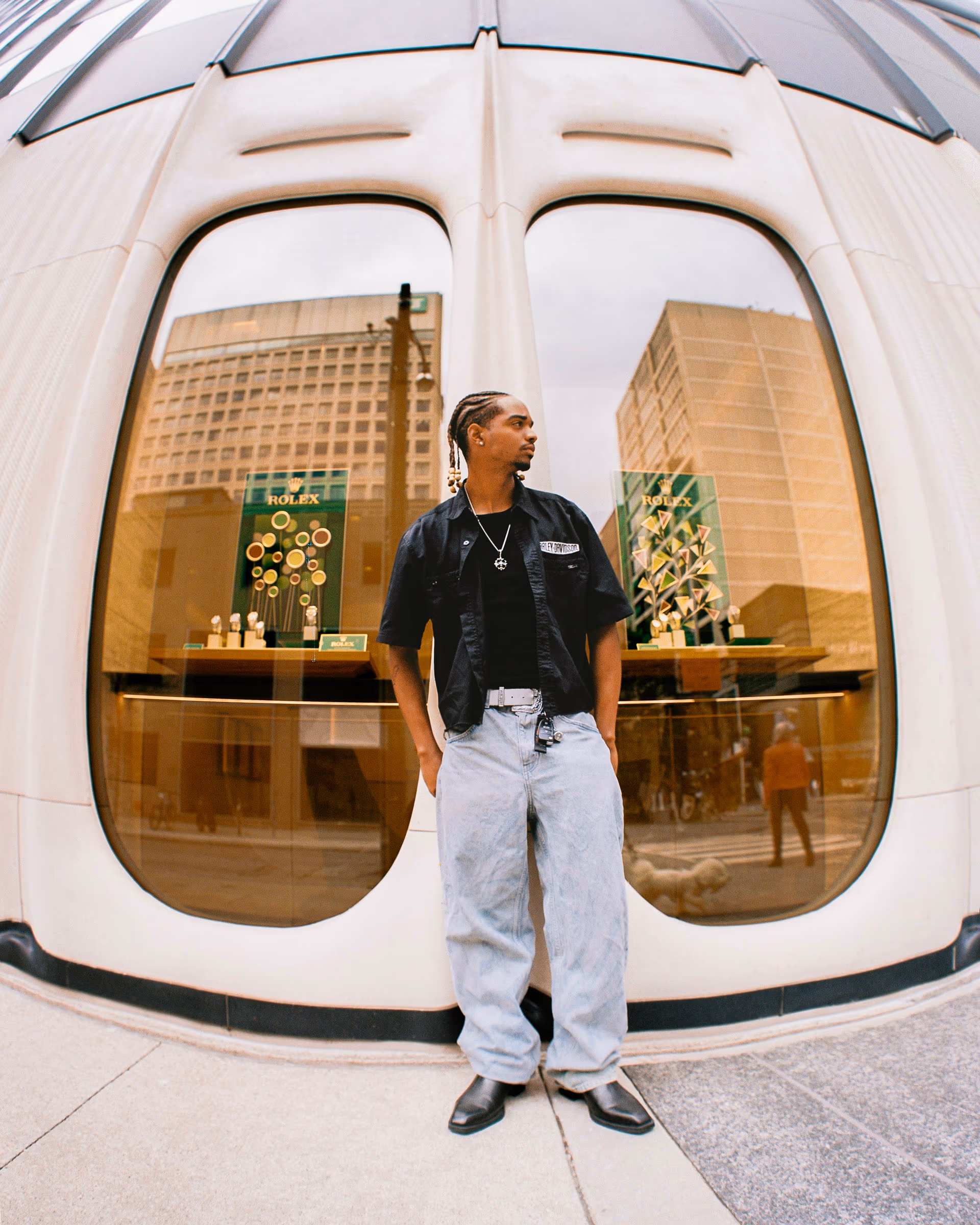 Samuel outside the gold-mirrored storefront in black