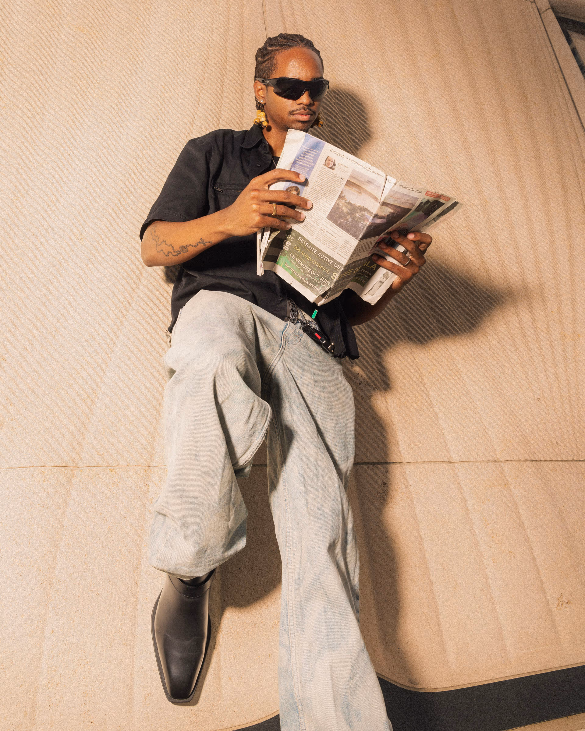 Sprawled across a curved concrete bench with the newspaper