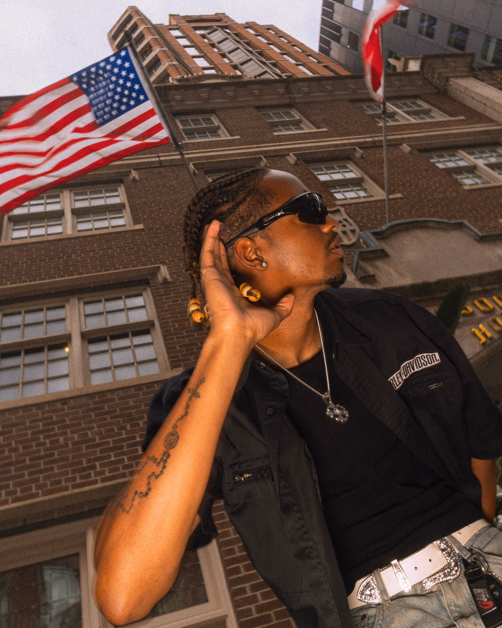 A portrait against brick and a flag, downtown