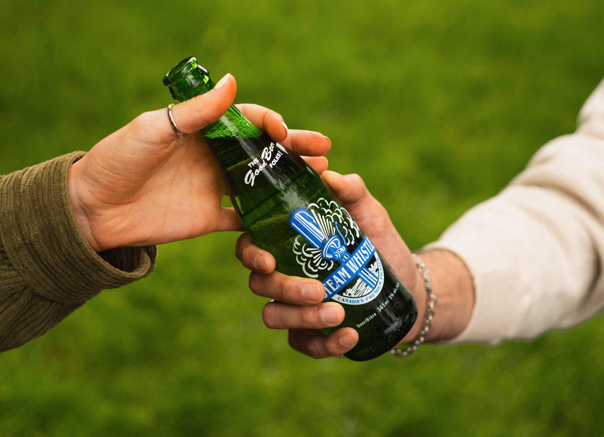 A bottle passed from one hand to another