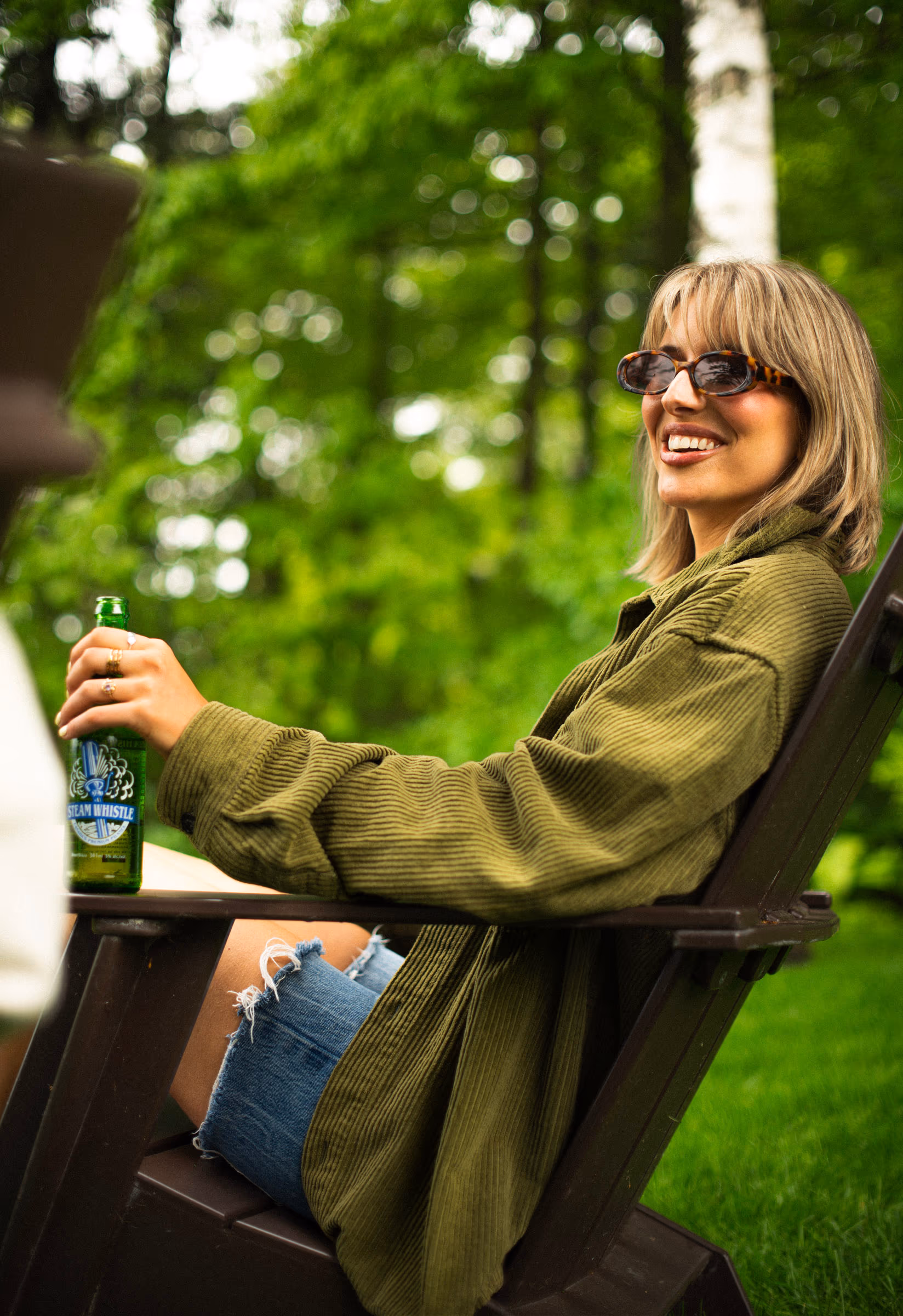 A smile from the Muskoka chair, bottle in hand