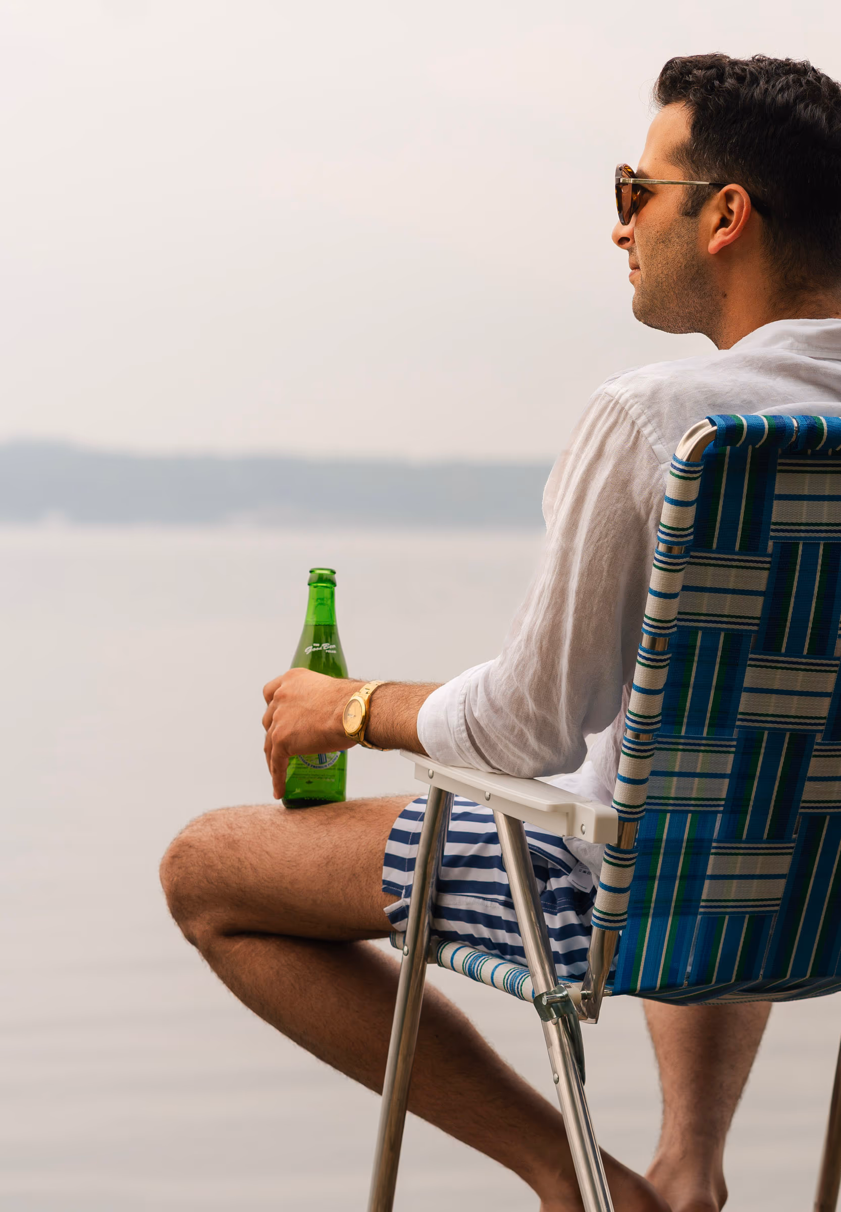 A quiet lakeside sip from the plaid lawn chair