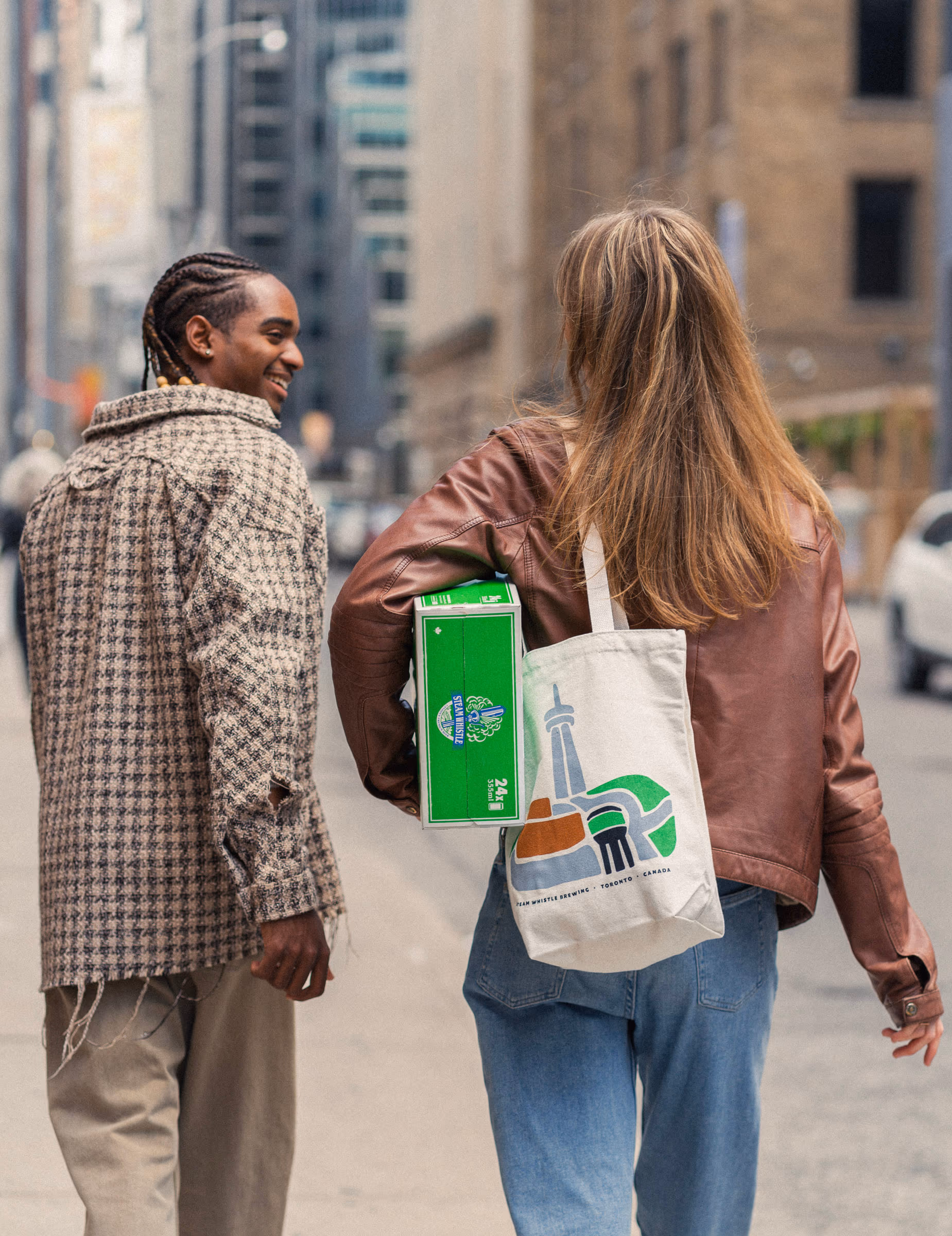 A couple heading home through downtown, tote over the shoulder