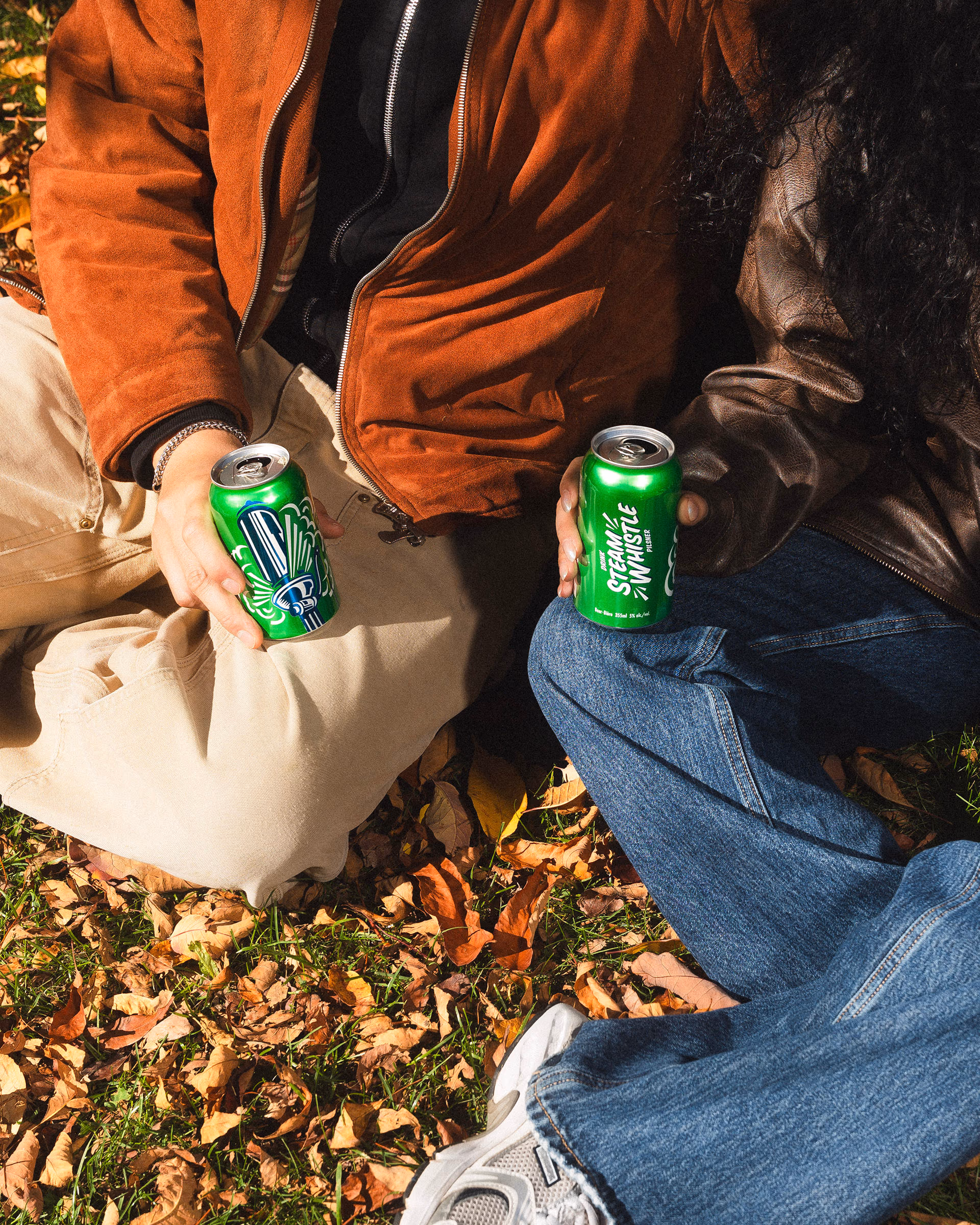 Sitting in the leaves with a can, sneakers crossed