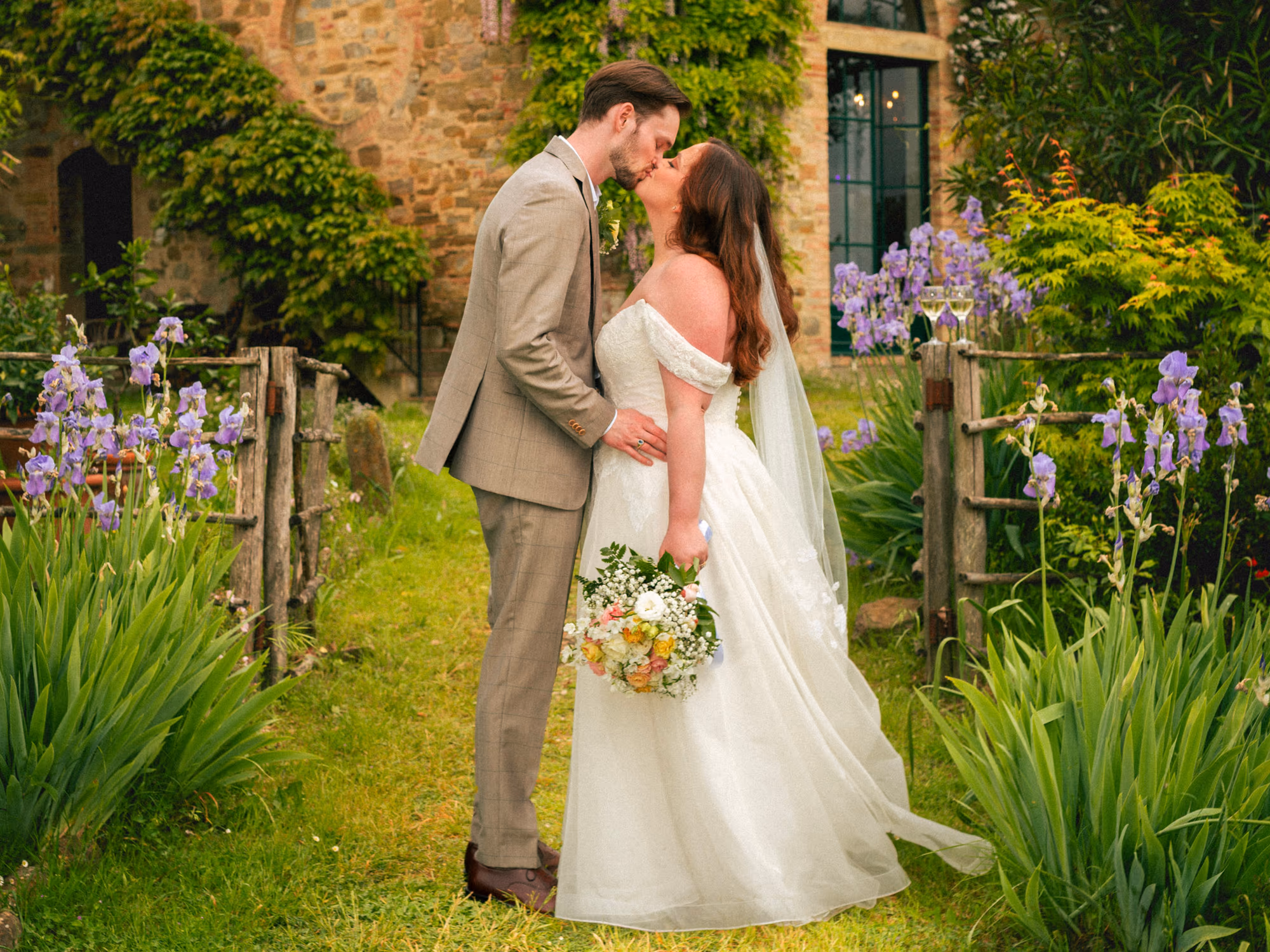 A kiss at the garden fence beneath the wisteria