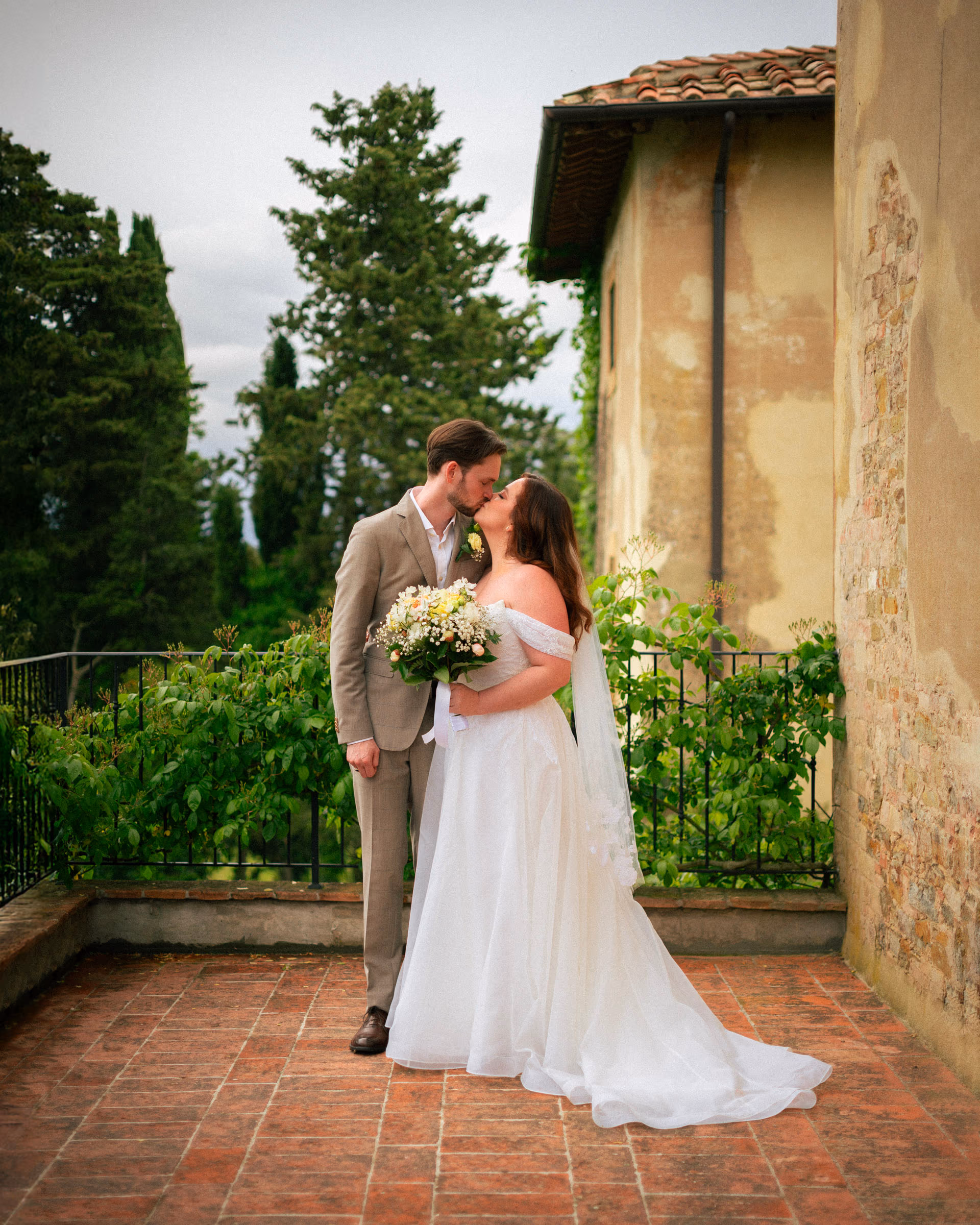 Bride and groom on the terrace, bouquet in hand
