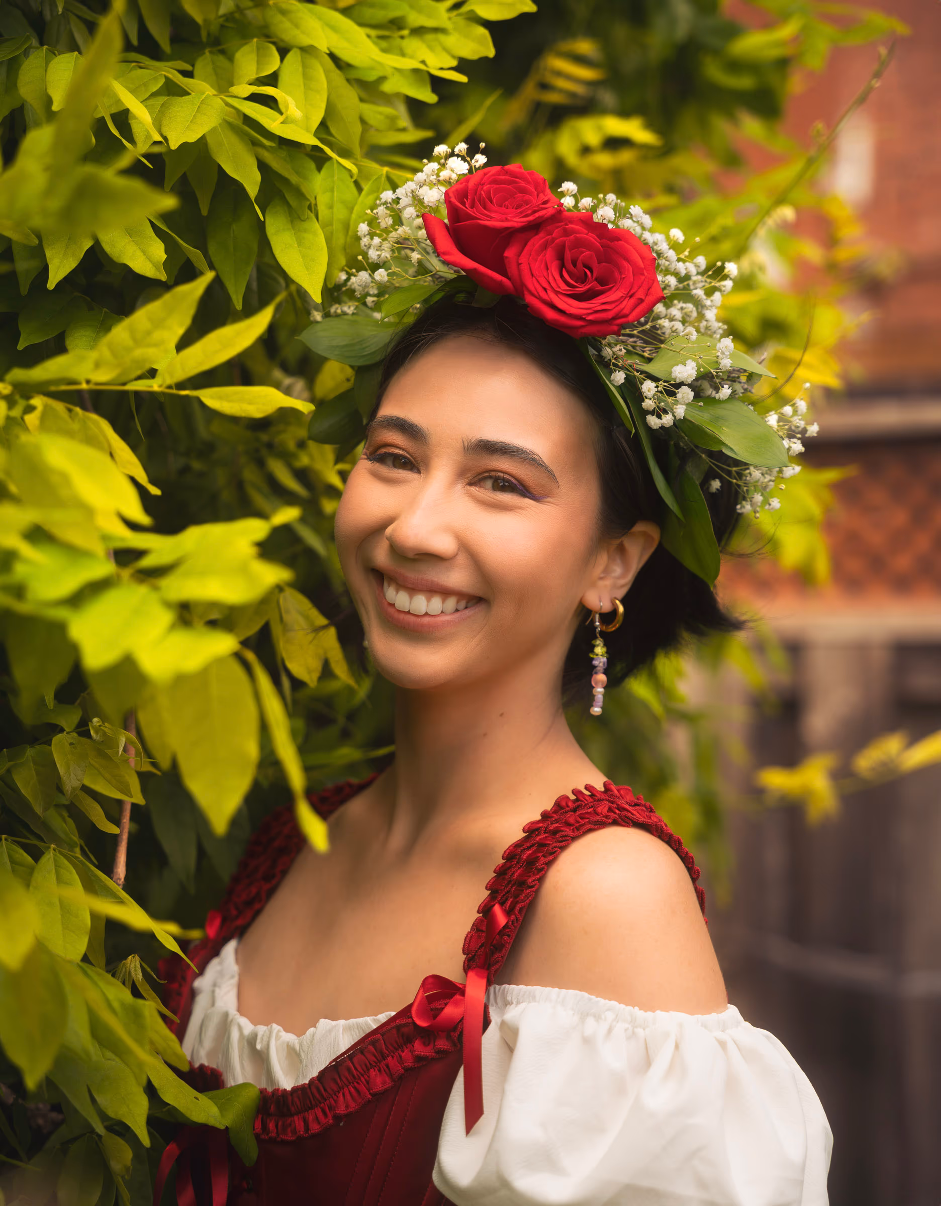 Tatianna smiling under the leaves, roses in her crown